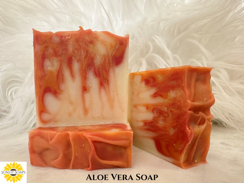 Aloe Vera Soap - Three orange and white soap bars on a textured white background with Sunlit Soaps branding,