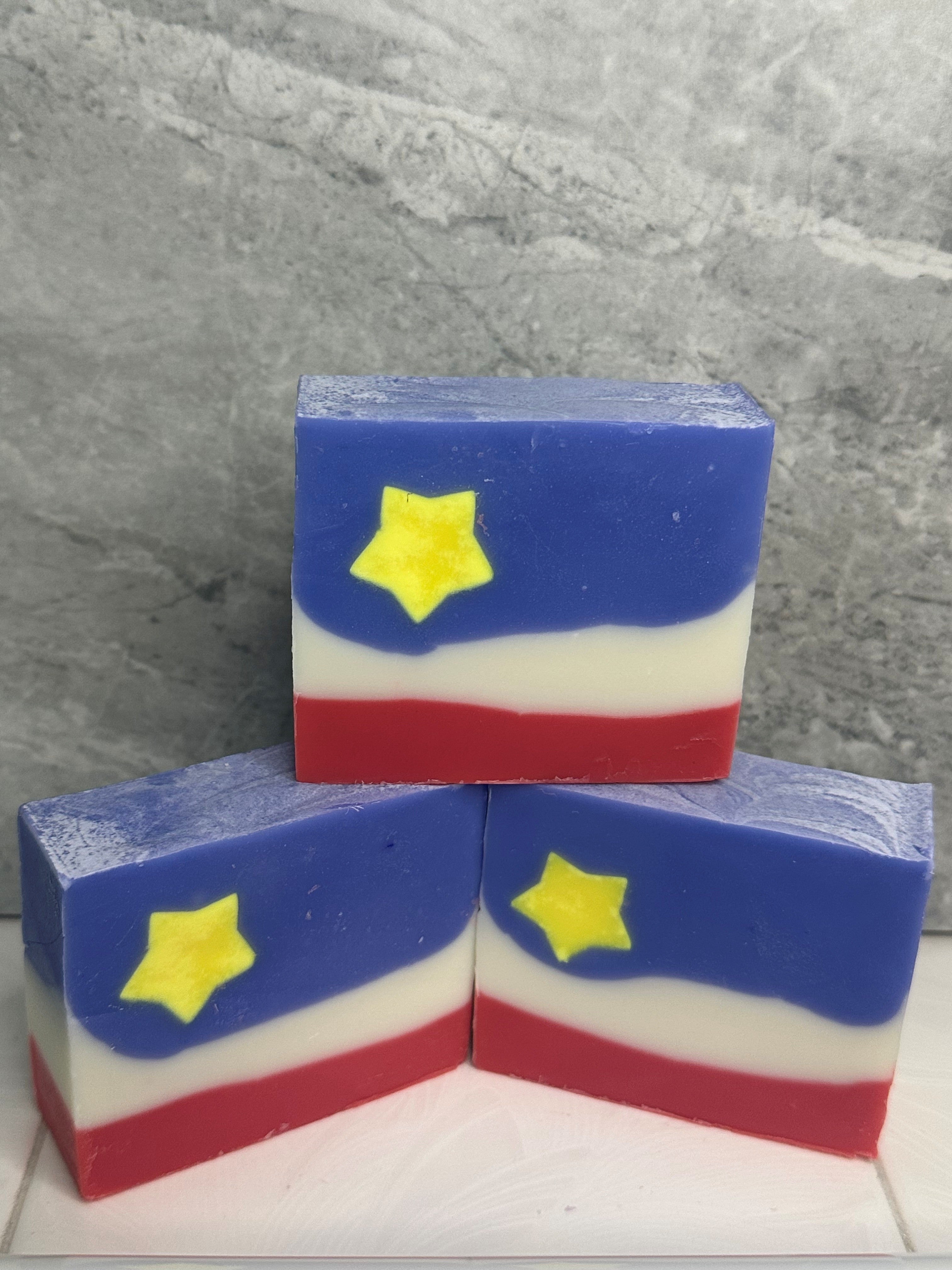 Three rectangular soap bars with a star design on a gray surface