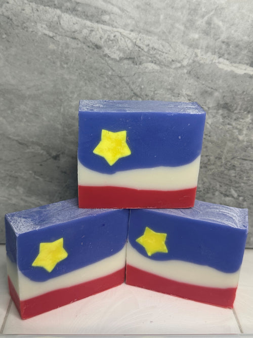Three rectangular soap bars with a star design on a gray surface