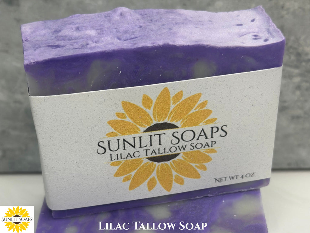 Bar of lilac tallow soap with Sunlit Soaps label on a gray background