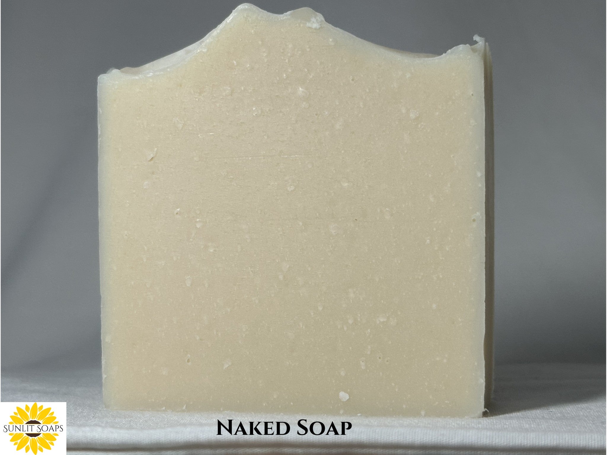 Back of the Bar of Naked Soap on a gray background with 'Sunlight Soaps' logo.