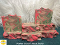 Swirled pink and green soap bars on a textured surface with 'Sunlitt Soaps' branding.