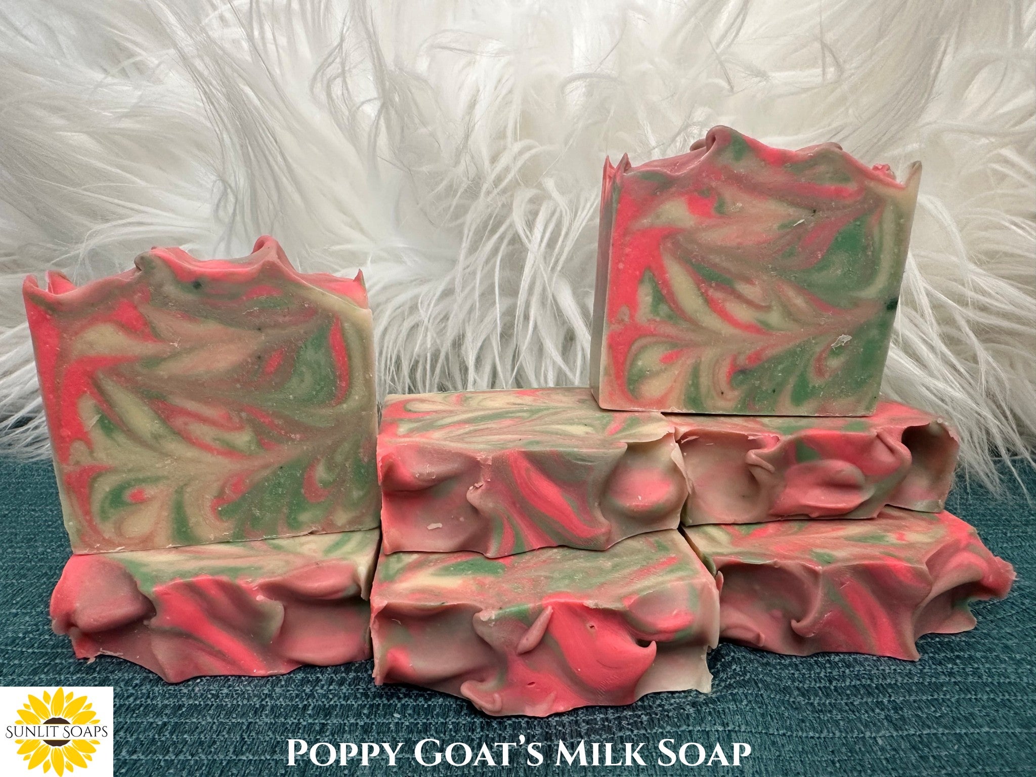 Swirled pink and green soap bars on a textured surface with 'Sunlitt Soaps' branding.