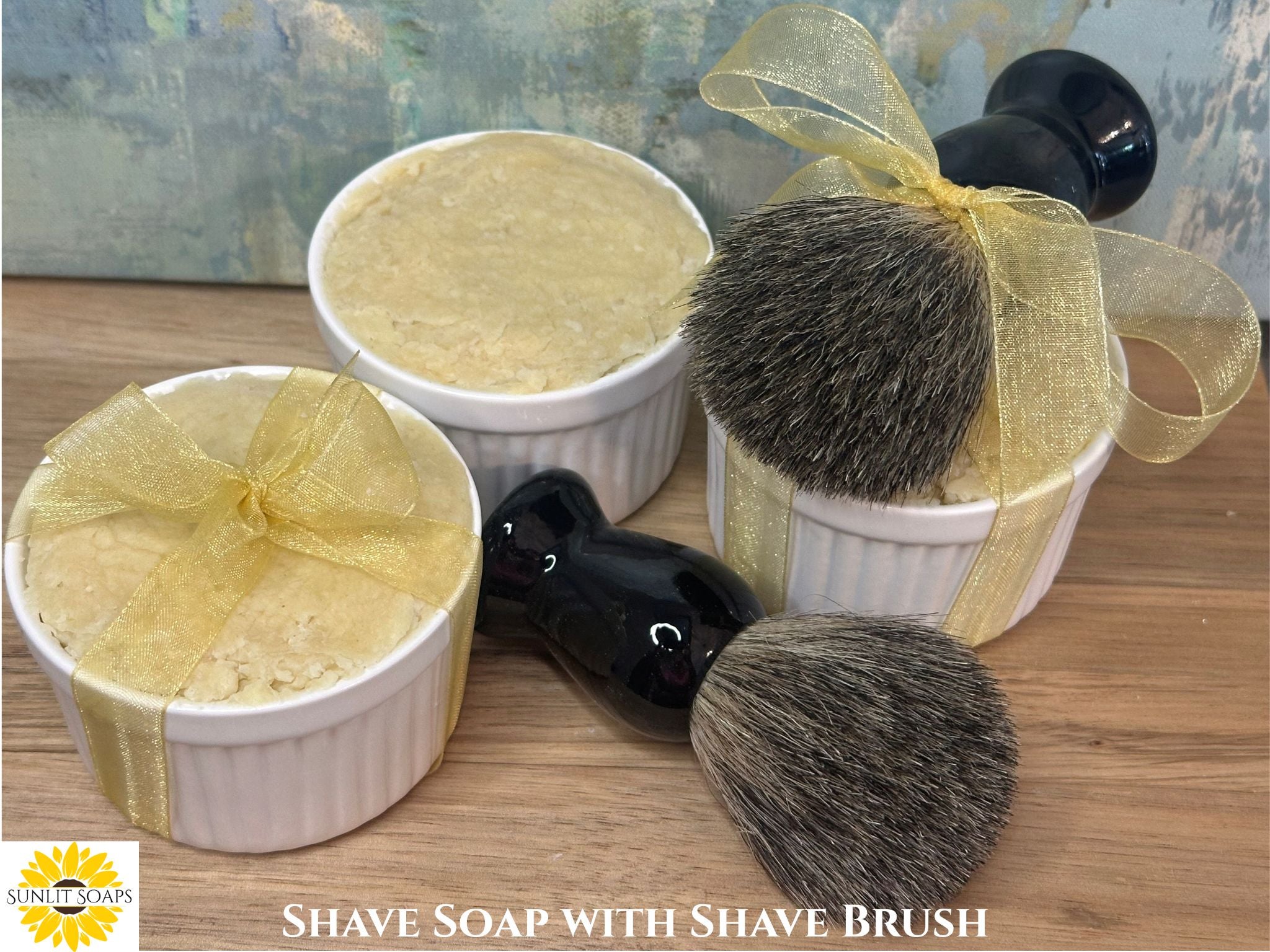 Shave soap in white containers with two brushes on a wooden surface, featuring 'Sunlit Soaps' branding.